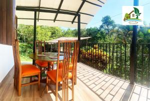 porche con mesa y sillas en el balcón en Casa Campestre Villa Lago en Quebradanegra