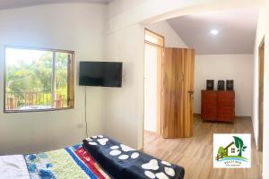 a bedroom with a bed and a flat screen tv at Casa Campestre Villa Lago in Quebradanegra