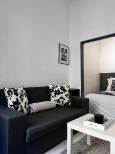 - un salon avec un canapé noir et un lit dans l'établissement Sublime Studio Festival Cannes, à Cannes