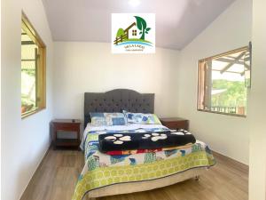 a bedroom with a bed and two windows at Casa Campestre Villa Lago in Quebradanegra