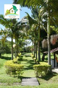 a row of palm trees in a park with a sign at Casa Campestre Villa Lago in Quebradanegra
