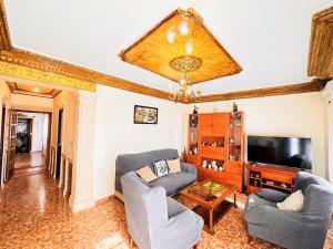 a living room with two chairs and a television at Casa Juan María in Alora