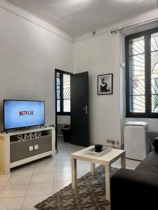 a living room with a tv and a table at Sublime Studio Festival Cannes in Cannes
