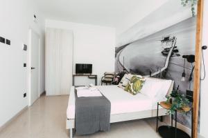 a bedroom with a white bed and a black and white painting at Le Camere ai Trabocchi in Vasto