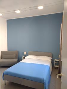 um quarto com uma cama grande e um sofá em LA REGGIA APARTMENTS MILAZZO em Milazzo