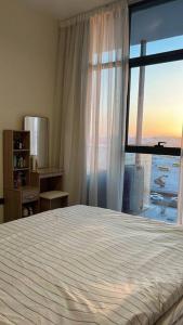 a bedroom with a bed and a large window at Home 4U in Dubai Center in Dubai