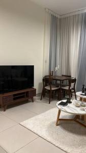 un salon avec une grande télévision et une table dans l'établissement Home 4U in Dubai Center, à Dubaï