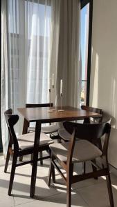 a wooden table and chairs in a room with a window at Home 4U in Dubai Center in Dubai