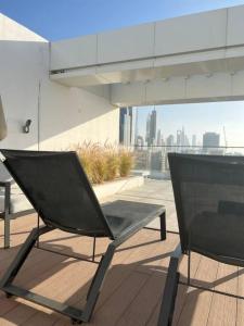 une chaise noire assise sur un balcon avec vue sur la ville dans l'établissement Home 4U in Dubai Center, à Dubaï