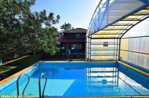 uma piscina ao lado de uma casa com um edifício em Villa Joe em Peqi‘in H̱adasha