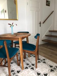 a dining room table with blue chairs and a mirror at Noclegi DobraNocka in Sąspów
