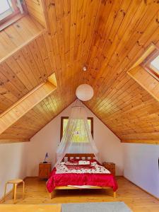 a bedroom with a bed with a hanging ceiling at Domek na końcu świata in Szymbark