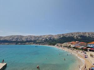 a view of a beach with people in the water at Apartments Eis in Baška