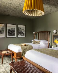 a bedroom with two beds and a chandelier at The Richland in Orange