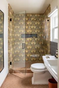 a bathroom with a shower with a toilet and a sink at The Richland in Orange