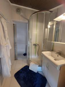 La salle de bains est pourvue d'une douche, d'un lavabo et d'un miroir. dans l'établissement Blue, à Pula