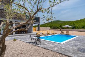 - une piscine dans une cour avec des chaises et un arbre dans l'établissement Villa Diva, à Stankovci