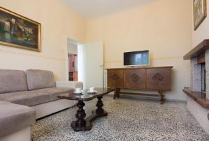 a living room with a couch and a tv at Villa Bruna Montefeltro, villetta indipendente circondata da un grande giardino in Perticara