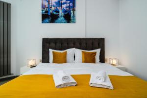 um quarto com uma cama grande com duas toalhas em Andreas - Pool & Spa Beach Resort em Mamaia Nord – Năvodari