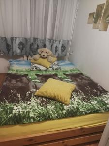 a teddy bear sitting on top of a bed at Vip apart in Gorlice