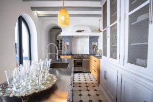 una cocina con fregadero y una mesa con copas de vino en Valencia Luxury Guest House, en Godella