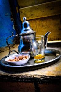une assiette avec un bol de noix et un verre de whisky dans l'établissement Oasis travel, à Tazouka