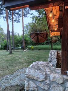 a porch with a hanging basket and a stone wall at Kajaki wino i śpiew - domek z sauną w otoczeniu lasów i sąsiedztwie zalewu in Zakrzówek Szlachecki