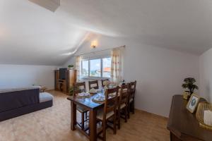 a living room with a table and chairs and a couch at Apartments Vranjić in Trogir