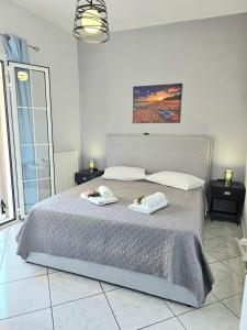 um quarto com uma cama grande com duas toalhas em Gosia Apartment GYM Included em Lixouri