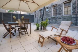 a patio with a table and chairs and an umbrella at Residence Santa Tecla in Trieste