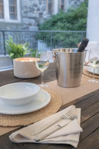 a wooden table with a plate and a glass of wine at Residence Santa Tecla in Trieste