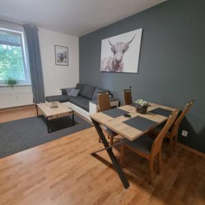 ein Wohnzimmer mit einem Tisch und einer Kuh an der Wand in der Unterkunft Apartmány Černý Tulipán 3 in Pilsen