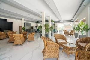 a lobby with wicker chairs and tables and a television at Sotirakis Hotel in Faliraki