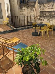 un patio con sillas, una mesa y una planta en La Terrasse du Saint-Didier, en Aviñón
