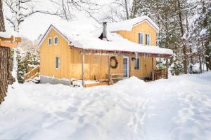 Una casa en la nieve con carámbanos. en Nature et tranquilité à une heure de Montréal, vue sur le lac en Saint-Calixte