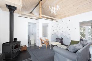 een woonkamer met een bank en een fornuis bij Nature et tranquilité à une heure de Montréal, vue sur le lac in Saint-Calixte