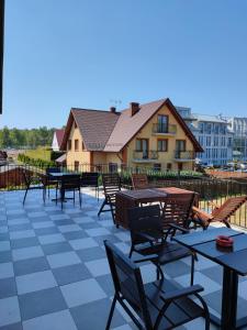 a patio with tables and chairs and a building at Noce i dnie in Białogóra