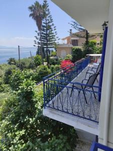 balcone con sedie e vista sull'oceano sullo sfondo di Blue and white apartments 3 a Benitses
