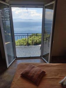 1 dormitorio con cama y vistas al océano en Blue and white apartments 3 en Benitses