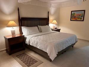 a bedroom with a large bed with two night stands and two lamps at Holiday Inn Merida, an IHG Hotel in Mérida