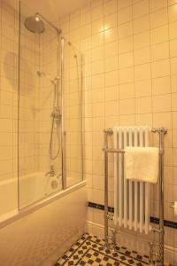 a bathroom with a shower and a tub and a towel at Feith Mhor Lodge in Carrbridge