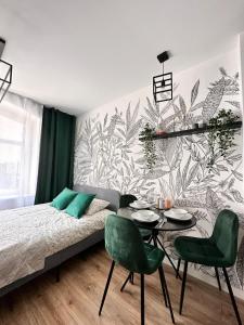 a bedroom with a bed and a table and chairs at Green Hill Apartments Katowice in Katowice