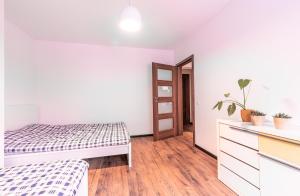 a bedroom with a bed and a dresser at Paprotkowy Zakątek in Polanica-Zdrój