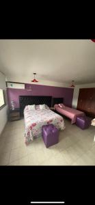 a bedroom with two beds and purple walls at APART HOTEL OFFICE céntrico in San Salvador de Jujuy