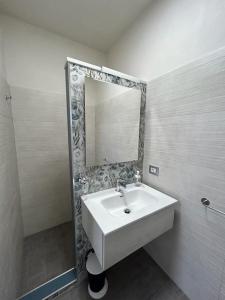 y baño con lavabo blanco y espejo. en Santorini 2.0, en San Pietro in Bevagna