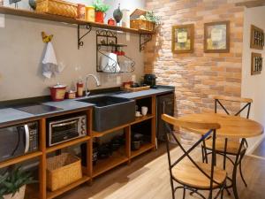 uma cozinha com um lavatório e uma mesa com cadeiras em Lofts Villa da Serra em Tiradentes