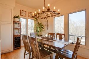 uma sala de jantar com uma mesa e cadeiras e um lustre em Landrum Treehouse - Hot Tub and Trail Access! em Landrum