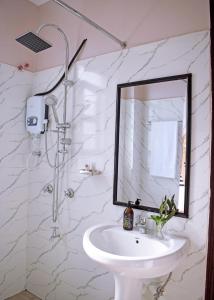 een witte badkamer met een wastafel en een spiegel bij Ilala House, Voi - 2 bed, 2 bath in Voi