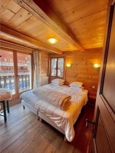 a bedroom with a bed in a wooden cabin at Résidences Delavay Les Pistes in Les Gets