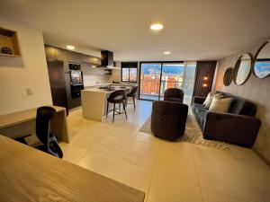 Apartamentos Gema by Cadissa في ميديلين: مطبخ وغرفة معيشة مع أريكة وكراسي
